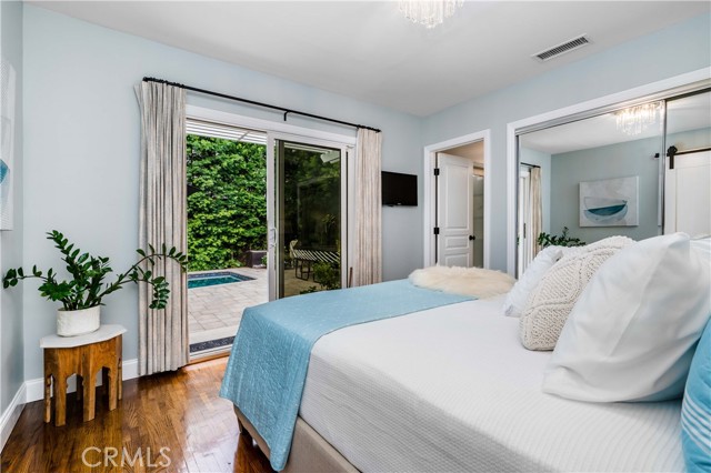 primary bedroom with pool & backyard views, glass sliding door