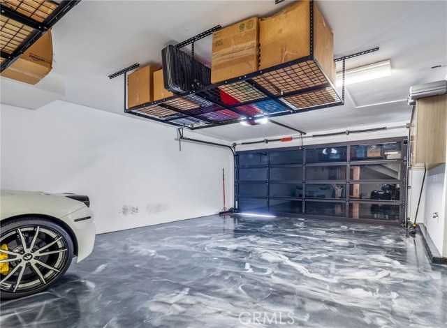 Garage - Custom blended epoxy floor and built-in storage racks.