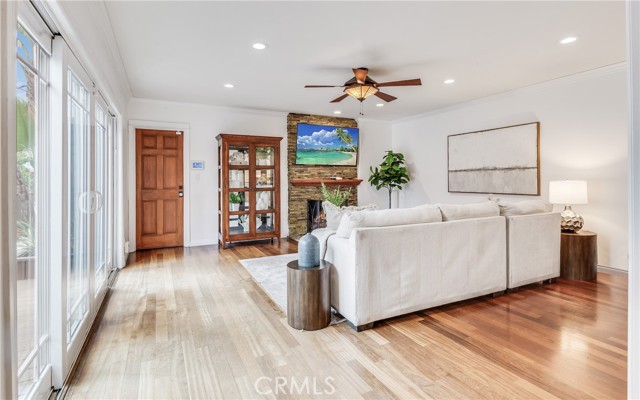 The beautiful living room features sliders to the entryway patio, hardwood floors, recessed lights and stacked stone fireplace