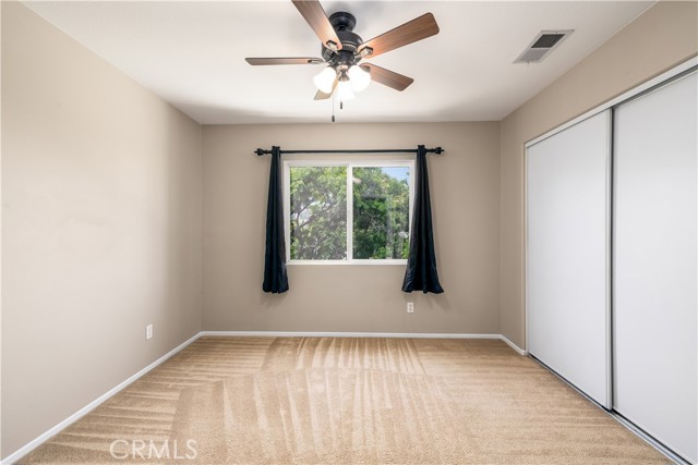 Third upstairs secondary bedroom with ceiling fan.