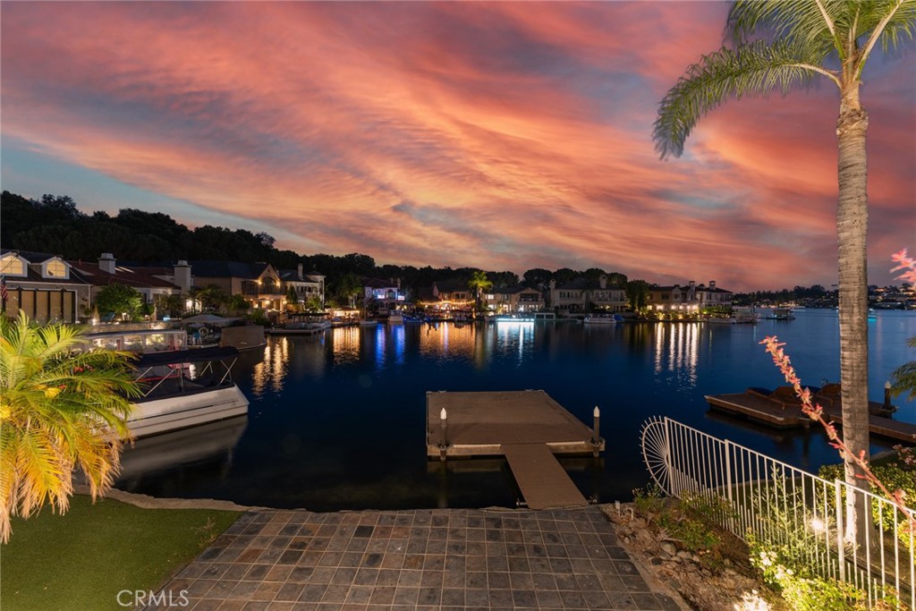 Huge price reduced! Seller motivated. Welcome to your dream waterfront estate on Lake Mission Viejo! This stunning contemporary home offers luxurious lakefront living with breathtaking water views from most living spaces. This 3,866 sq ft gem features 5 bedrooms, 4 baths, a powder room, and an oversized attic storage space after lovingly remodeled for years. 

On the main floor, you'll find a convenient bedroom suite. Upstairs, the master suite boasts a high ceiling, walk-in closet, spacious bathroom, and balcony with spectacular lake views. An adjoining office has been transformed into a second bedroom with its own bathroom and a large deck.

The formal living room features a tall cathedral ceiling and fireplace. The formal dining room opens to the rear patio and yard. The chef's kitchen is a delight with custom cabinetry, an extra-large granite center island and countertops, seamlessly connected to a spacious family room with custom built-ins, a wine cabinet, and a fireplace. Sliding doors open to a perfect entertainment area in the well-maintained backyard, complete with fruit trees, flowers, and a private boat dock with direct lake access.

The front entrance has been exquisitely remodeled to create a regal and impressive first impression, featuring stately double doors framed by ornate columns and detailed stonework, all set behind an elegant electric-gated entry that welcomes you home in style and security.

Two A/C units serve upstairs and downstairs separately. A built-in BBQ station is perfect for parties and entertainment. Limestone flooring on the first floor and hardwood upstairs, including the stairway, add elegance. The home includes a 3-car garage and is part of the Lake Mission Viejo Association, providing access to summer concerts, swimming facilities, boating, and holiday activities.

If you love the water and dream of a waterfront lifestyle, this is your chance to make it a reality.