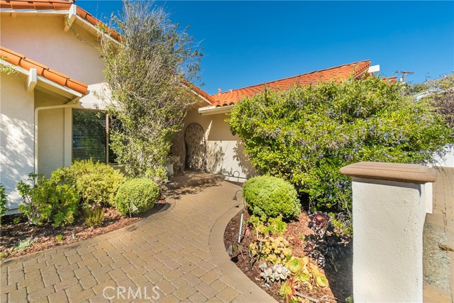 Lush landscaping in private courtyard frames the entry to the home.