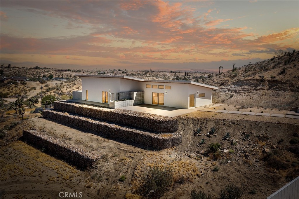 5115 Hilton Avenue Yucca Valley, California Gorgeous Brand NEW HOME SEE THE VIDEO ABOVE!! Million Dollar Views! One of a kind! Come take a look! Exceptional Modern Open Concept Living home with high ceilings Throughout! Step into this 2 bedroom, 2 bath modern inspired home and experience the most unbelievable panoramic views. Every window has a view! This perfect little desert retreat is located in a private area and the views are panoramic and inspiring. Custom-cut concrete flooring throughout. Modern kitchen with quartz countertops and fixtures. Imagine relaxing high on a hill watching a captivating sunrise from this stunning home! modern best describes this very unique new build. Sited on over 2.29 this stunning residence will not disappoint! Keep your utility bills low with a paid-for solar system Beautifully landscaped front of home and backyard with outdoor fireplace for entertaining or having coffee in the morning with a gorgeous peaceful view! This home is Simply STUNNING! The detail in mind.Secure, serene, supreme. Step out onto the patio and view boulders and beauty and catch beautiful sunrises and sunsets! Enjoy the city lights and gorgeous views of the mountains. This area offers great opportunities for vacation rental, and or private residence Joshua Tree National Monument is about 20 miles away wherein in 2019 almost 3 million tourists visited... All amenities are minutes from Yucca Valley. 20 minutes from GMARS - Goat Mountain Astronomical Research Station, owned by the Riverside Astronomical Society, this part of Landers is a dark sky zone renowned for its stargazing with the best views of the Milky Way in the area. 10 minutes to La Copine, 20 minutes to the Integratron,., 15 minutes to Pappy and Harriets, Pioneertown, Location the best!. If you are searching for a getaway unlike any other or One of a kind unique AIRBNB schedule showing today!