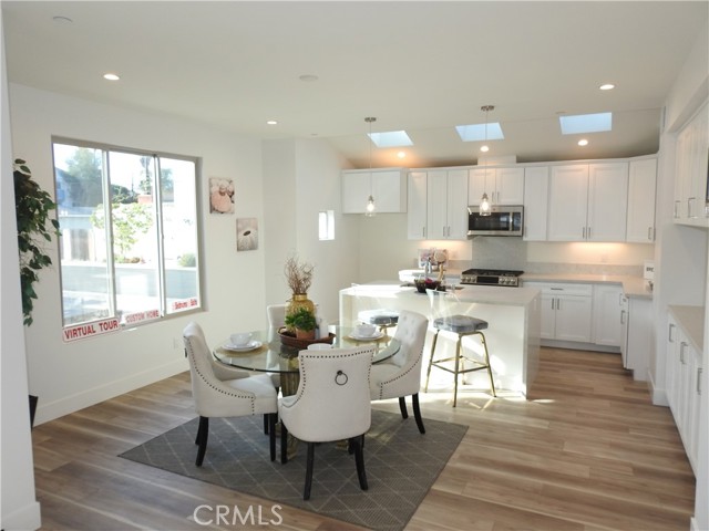 Open combo kitchen dinning room area with built in side board countertop and cabinets for storage.