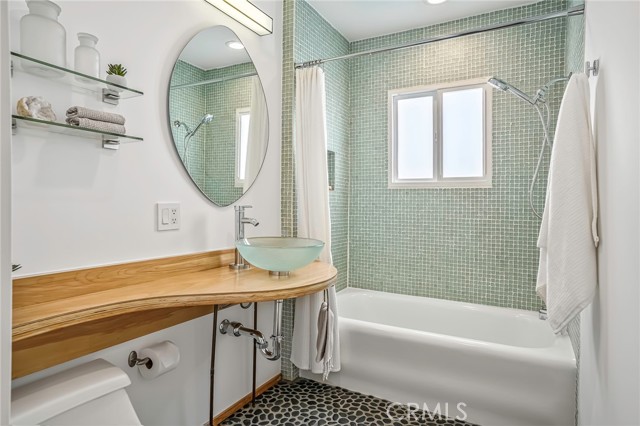 Gorgeous bathroom tile the color of the ocean. This bathroom is upstairs in the hallway between the kitchen and street side living room.