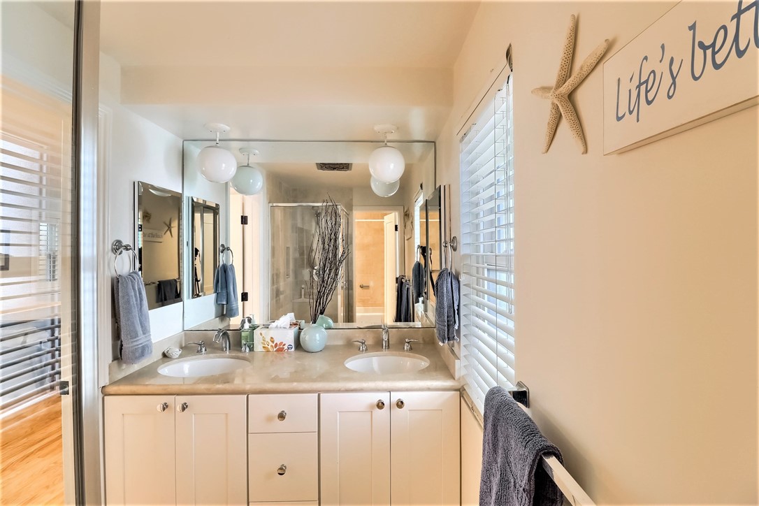 The Second Bathroom has a Large Vanity with Double Sinks and Stone Surfaces.