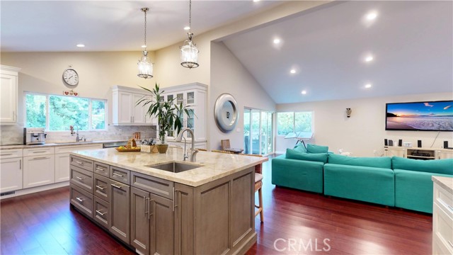 View looking from Pantry toward kitchen and living room with vaulted ceilings