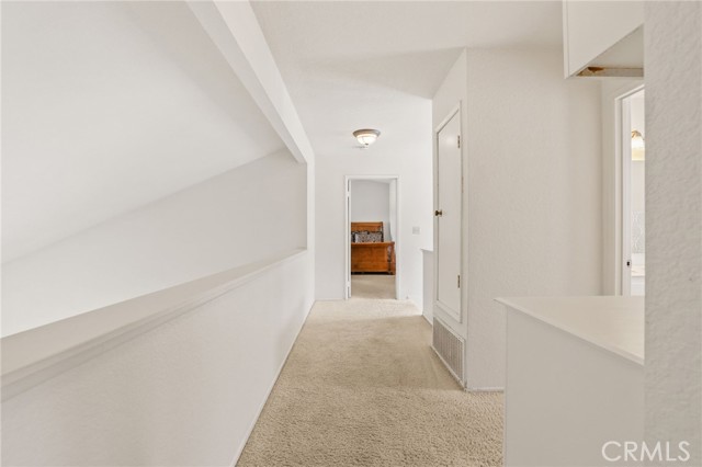 The primary suite is on the opposite side of the hallway, away from the two secondary bedrooms. The second full bathroom is half way to the right.