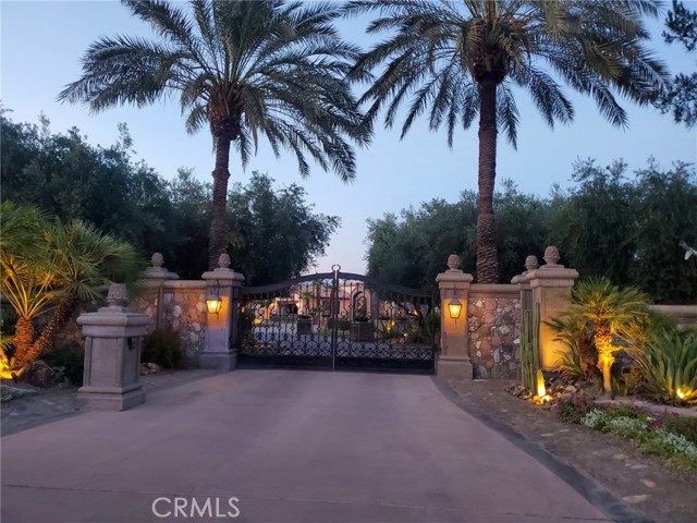 Designed and built by architect Juan Carlos Ochoa in 1993. This custom Mediterranean inspired villa is on the market in Clancy Lane Estates. This work of art inspired by a Spanish monastery can be your Architectual masterpiece of design and old world craftsmanship. See amazing mature cactus gardens and stone Pathway emcompassed by an olive tree grove on a little less than an acre. Entering through your private wrought iron custom gates you are immediately transported into old world charm in this completely walled Villa. The enchanting grounds include 3 operating stone fountains, one 10' tall in the center of a six car motorcourt plus an all tiled swimming pool with its own stone water feature and a separate all tiled spa in a stone grotto. Directly off the pool is a Pavilion with outdoor chef's kitchen that has everything you need. There are 2 gas fire bowls off the pool and a backyard 4 sided stone firepit.Before you set foot into the home you instantly recognize the impeccable craftsmenship and exquisite finishes. Large satillo tile floors and hand hewn oak plank floors throughout. This home was built to last selecting only the finest materials available in 1993 from hand hewn beams, vaulted ceilings and achways, venetian smooth plaster walls with rounded corners, stone corbels, stone surrounds, stone boncos as well as two hand-carved stone fireplaces. The walls are extra thick with the dual pane windows, and electric blinds on the french doors as well, all for added insulation. Italian hand made doors and windows match the hand-made Italian cabinetry. Built in 1993 and completely restored to new inside and out, the home has 4 bedrooms all with ensuite baths with hand-painted Spanish tiles and 2 half baths, one inside and the other poolside. The chef's kitchen has a leaded glass lighted ceiling between the beams, a Wolf gas stove with electric ovens, plenty of built in refrigeration and freezers, plus a 200 bottle custom wine cabinet in the breakfast nook, living room, formal dining room, FR, and gorgeous white marble and quartz countertops throughout, including the laundry room with a sub-zero frig and freezer. There are 2 large garages, one attached and the other detached with their own motorcourt, each with built-in storage.There can be no dispute that this magestic villa, located in Clancy Lane Ests on a secluded flag lot, has the most perfect location in Coachella
