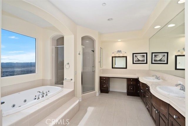 Primary bathroom with shower, soaking tub and 2 vanities. also with views