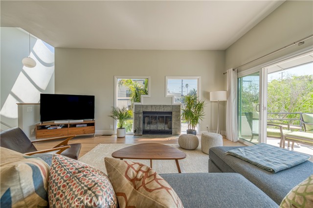 Living room centers aroudn the fireplace. Thanks to an end unit location, there are windows on three different walls bringing in a lot of light.