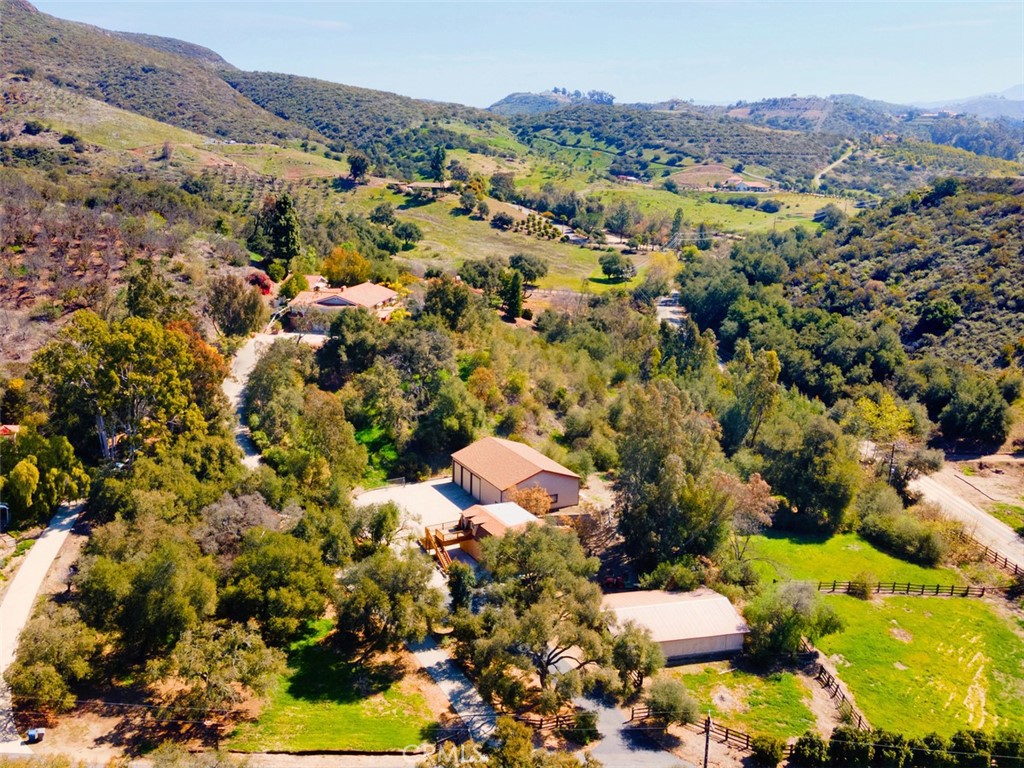 43895 De Luz Road Temecula, California Welcome home to this impressive multi family ranch estate located on 5.46 acres in the exclusive area of De Luz. This one truly has it all featuring a 3126 asf. main home, 1120 asf. guest home, 838 asf. casita, pool, 2928 asf. RV garage, 1020 asf. workshop, 2120 asf. 6 stall barn, pastures, lush mature plants, tress & a prime location. The main home features 4 bedrooms, 3 baths, formal dining, family room w/ wet bar, fireplace & cathedral wood beam ceiling, gourmet kitchen w/ granite slab counter tops, center island, double ovens, 4 burner cook top, BBQ grill & spacious dining area, laundry/sewing/craft room w/ loads of storage, master suite w/ walk-in closet & luxury master bath, multiple bench seat windows w/ storage, birch cabinetry, beautiful hardwood flooring from LA high school gymnasium & antique brick throughout, veranda, covered patio, fountains, sparkling pool, pool bath, family fruit orchard, oversized 3 car garage w/ sink plus a craft & wine room. 1120 asf. newly remodeled guest home w/ full kitchen, 3 bedrooms, bath, living room & wood deck. 838 asf. casita w/ 1 bedroom, 1 bath, living room w/ wood beamed ceiling, pot belly stove & kitchenette. 2938 asf. steel framed RV garage w/ three 14' x 11' doors, electric, water, sink, pit for oil changes etc., concrete pad for parking & RV clean out. 1020 asf. workshop w/ sink, workbenches & bath. 6 stall barn w/ 2 turnouts, tack room, hay storage, wash rack & 2 pastures. Country living at its best! Must see!