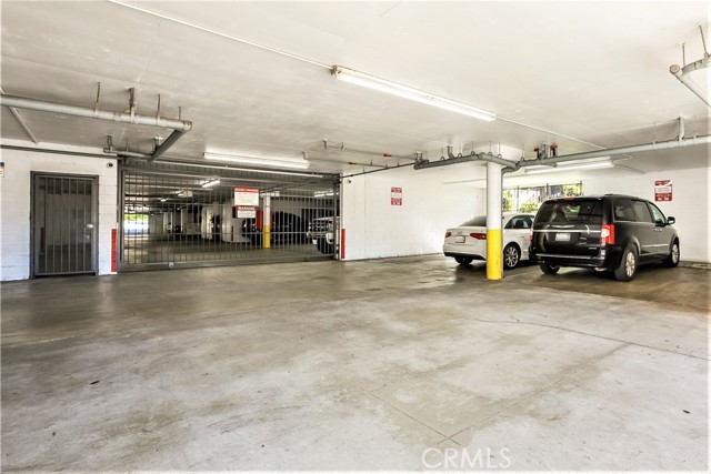 This is the West Garage Entrance with it's Rolling Security gate, Keyed Side Security Door and the Eight Guest Parking Spaces by Permit.