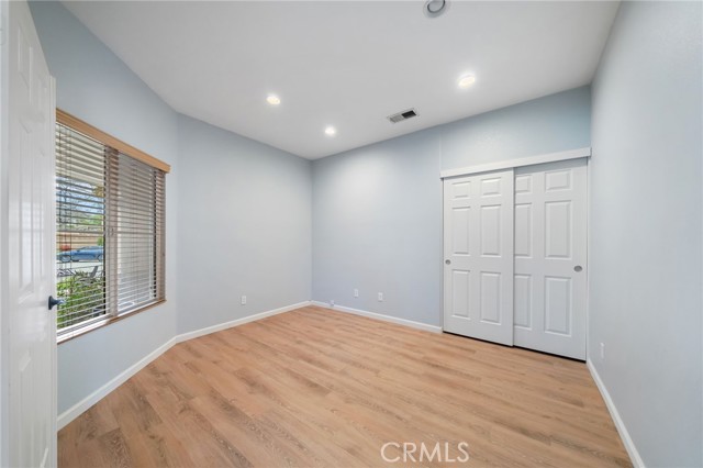 First spacious guest bedroom with double doors and closet, could be an office