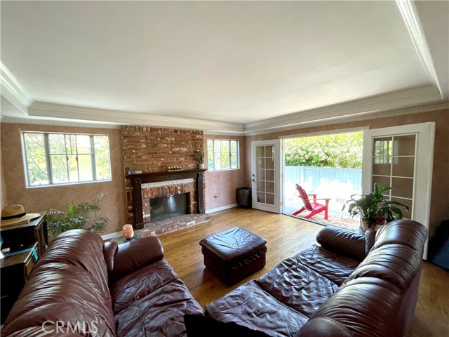 Hard wood flooring and used brick fireplace, typically stately decorator choices, make this living space warm and charming.