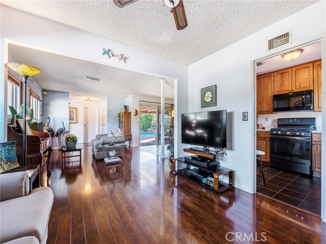 Den enjoys the view into the kitchen and the living area with the sparkling pool in the background.