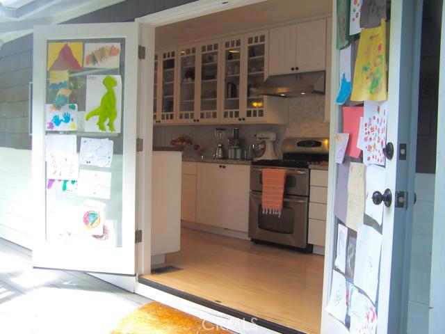 Coastal Kitchen. French Door Entry from Wraparound Deck. (Cheerfully Decorated with Children\'s Art).