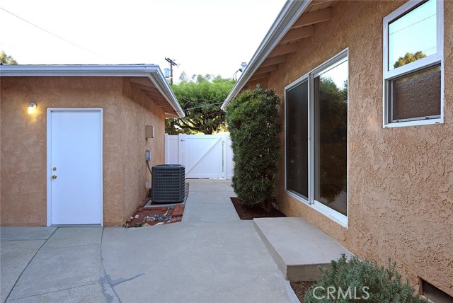 View of 2-car garage (left), 5-foot wide gate to driveway (center), Master Bedroom slider and Master Bath (right)