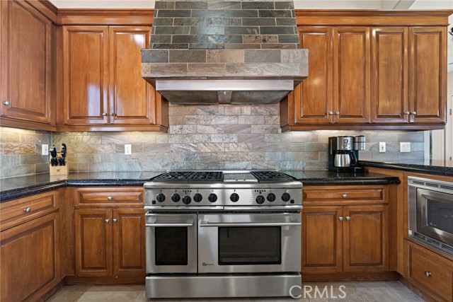 Chef's kitchen includes range with 6 burner stove.