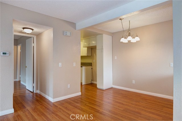 great view of the Dining area and hallway showing the updated flooring, paint, chandler, and light fixture...