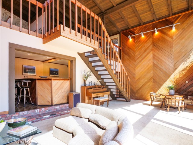 Stairway to downstairs entertainment area with wet bar, family room and bed and bath with sauna