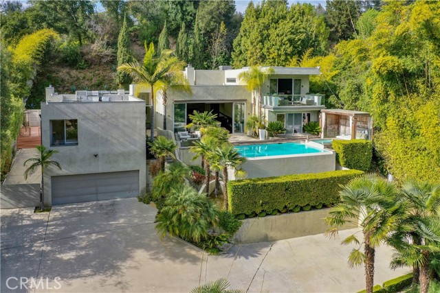 2731 Hutton Drive Beverly Hills, California This secluded Beverly Hills oasis is designed with privacy and comfort in mind, with contemporary architecture living harmoniously within nature. Beyond the secure front gate and up a well a manicured driveway sits this modern marvel boasting elegance and charm. As you enter the home you are welcomed by floor to ceiling glass doors that fill the home with natural light. The main level features an expansive living room with vaulted ceilings, a fireplace, gorgeous shelving and enormous sliding glass doors that would have all the neighbors talking - if they weren't so private. The front patio showcases a large infinity pool, hot tub and cabana with serene and scenic views unlike any other in Beverly Hills. An impeccable guest suite and office area occupy one wing of the first floor, only a few paces away from a formal dining room with sliding glass doors that provide every dinner party with an experience unto itself. The chef's kitchen showcases a massive marble island and top end, stainless steel appliances throughout. Leading into a family room featuring a floor to ceiling brick fireplace and sliding glass doors that strike the perfect balance of indoor-outdoor living. As you travel down the main thoroughfare of the home, you'll be moved by architectural elegance as you pass by a private massage parlor, fitness center and an in home music studio that has inspired some of the industry's biggest hits. A truly spectacular glass stairwell, showcases a wall of outdoor bamboo trees and leads you up to the master suite that comprises the entire second floor. The bedroom features immaculate wood flooring, high ceilings, a private deck and reinvigorating views that breathe new life into every morning sunrise. The suite also features an impeccable master closet that would color James Bond red with envy. The ensuite master bathroom is truly a sight to behold. Adorned with a gorgeous brick wall, reclaimed wood finishes, a rainforest like master shower and floor to ceiling corner windows that showcase all of nature's bounty; your morning routine will never be the same again. Sitting atop a sprawling half acre lot, this incredible Beverly Hills property encompasses that of your own personal retreat with a rare mix of privacy and luxury. Welcome To 2731 Hutton Drive. https://my.matterport.com/show/?m=JDkM56U7yUF