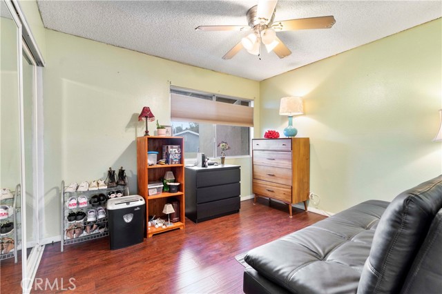 Spacious second bedroom with ceiling fan, mirrored closet doors, laminate flooring and blinds that open from top or bottom.