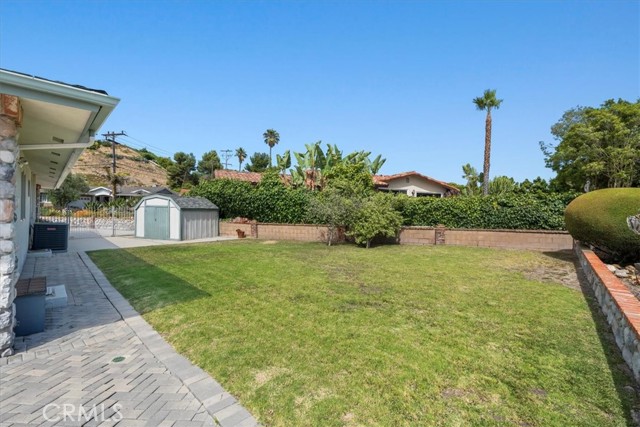 Outdoor pavers leading into vast open grass area, plus outdoor shed.