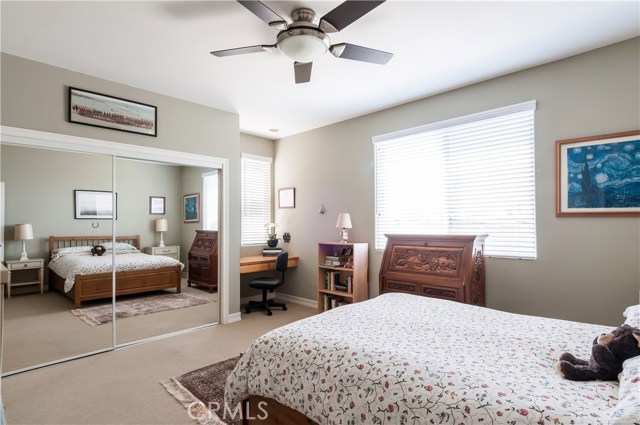 Bedroom 3 - with built-in desk, ceiling fan and large mirrored wardrobe.