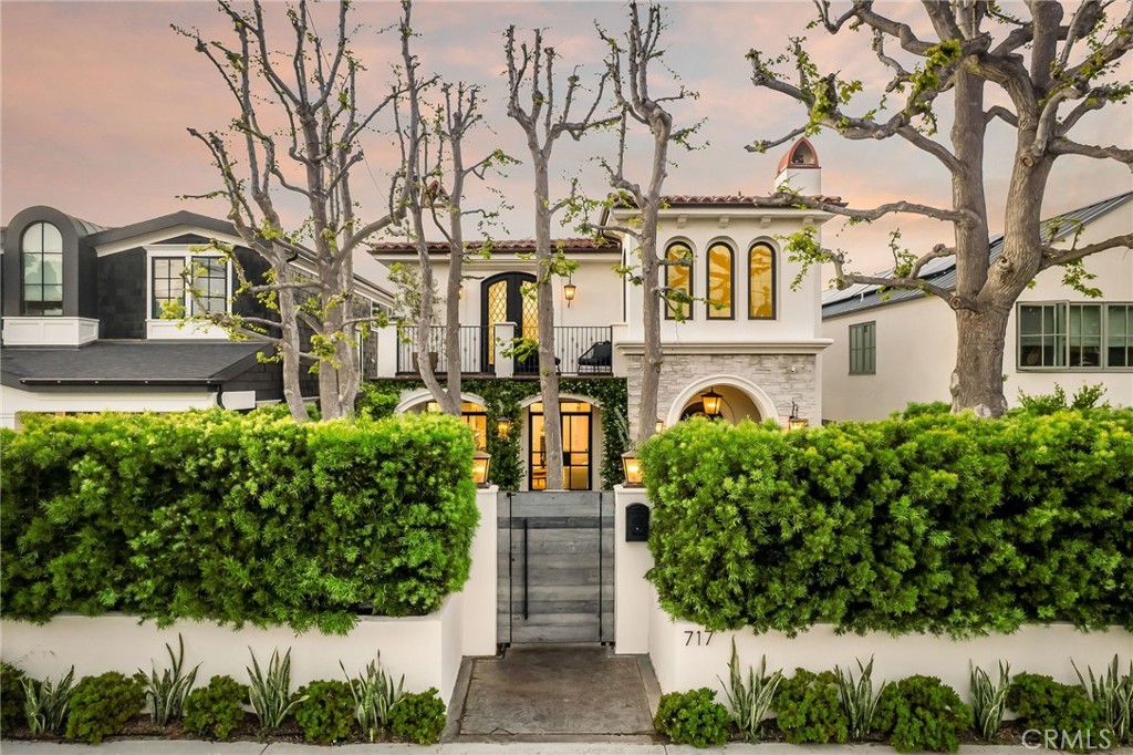 717 35th Street Manhattan Beach, California Contemporary Mediterranean with Custom Detail
This custom-quality estate with elevated Architectural Digest-worthy design offers a unique floorplan, upgraded finishes, vibrant outdoor spaces and exceptional curb appeal.
Nestled behind a custom wood gate and high hedges with a spacious, lushly landscaped front yard marked by soaring trees for added shade and privacy, this 4-bedroom, 6-bath, Santa Barbara-style residence features archways draped in jasmine vines and a wrought iron balcony, fusing Old World refinement and a fresh contemporary aesthetic that sets the tone for a high-touch interior featuring coffered ceilings, wood floors, refined fireplaces, neutral hues and Carrera marble throughout.
Highlighting two luminous living spaces that open to both the front and back yard oases featuring tranquil water features, fire pits and a built-in BBQ, the unique floorplan also features a showpiece chef’s kitchen with Thermador appliances, ample storage, walk-in pantry, and eat-in kitchen island with adjacent dining room and dream 175-bottle wine display. Upstairs offerings include the sumptuous primary suite with secluded balcony and ensuite spa bath with marble walk-in shower, sculptural soaking tub and two walk-in closets. Just off the primary suite, a bonus room/flex space is easily transformable for use as a nursery or office/study, while the kids’ wing houses two bedrooms with ensuite baths, in addition to a separate family room that is ideal as a media and hangout space and large enough for conversion into a fifth bedroom.
Outfitted in smart technology, including in-house speakers powered by Sonos and a reverse osmosis drinking water system, the house is prewired for interior and exterior security and also includes three AC zones, an EV charger, two-car garage and parking for four vehicles, plus an elevator.
Located in the Tree Section, the property is mere minutes to the sand and splendors of Manhattan Village and downtown Manhattan Beach.