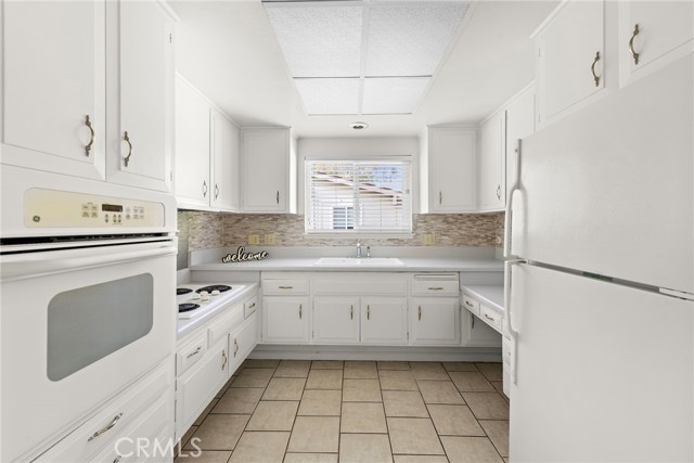 Spacious Full size kitchen with lovely custom back-splash on walls below cabinets, and above sink.