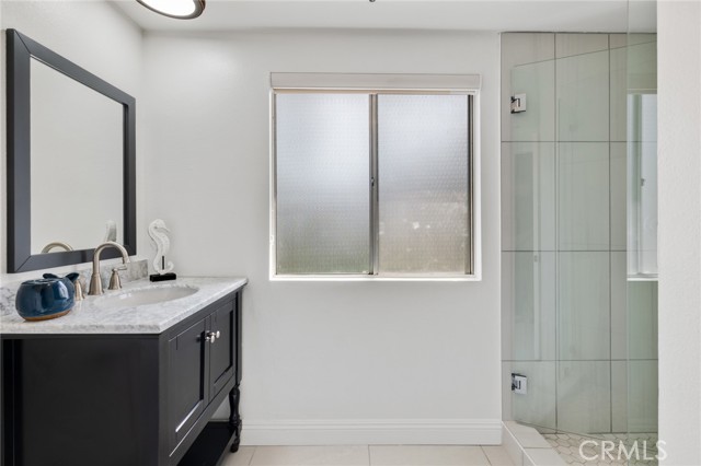 Master bath with new vanities, tile flooring and shower.