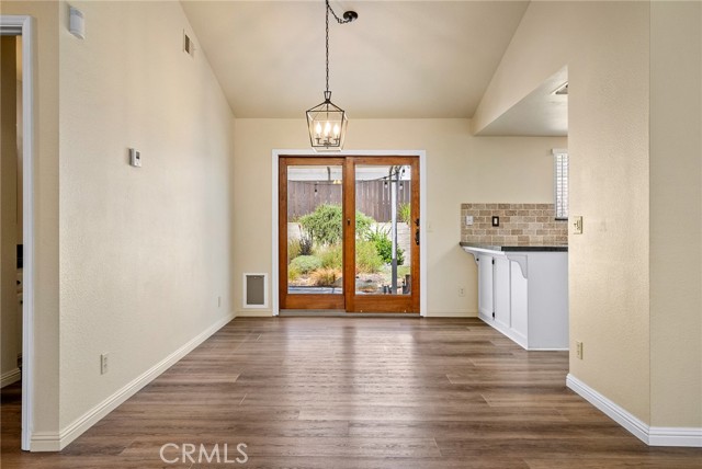 The dining area features a handsome drop chandelier and large sliding glass door that leads out to the backyard.