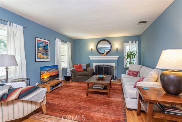 Enter into the spacious living room with warm, inviting fireplace, smooth ceilings, and gleaming hardwood floors!