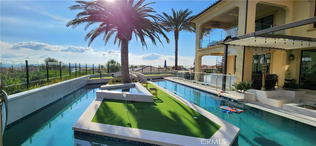 ***Private Resort Estate*** Modern Architectural Gem nestled on a EXCLUSIVE prime CORNER lot with breathtaking mountain and OCEAN VIEWS w/ vistas of Catalina Island. This 5-bedroom haven w/ Open Air POOL HOUSE w/ Bathroom redefines opulence with its resort-inspired outdoor oasis and meticulously crafted interiors, offering a lifestyle of sophistication and leisure. 

Resort-Style Outdoor Amenities allow you to dive into a swimmer’s paradise featuring a LAZY RIVER powered by a state-of-the-art PENTAIR INTELLICENTER and a commercial RIVER FLOW SYSTEM.  Olympic-length lap pool, an INFINITY WATERFLOW cascading next to a modern SUNKEN FIREPIT, two BEACH-designed pool BAJAS for ultimate relaxation. A glass tile JACUZZI and FUJIWA JAPANESE-painted tiles elevate the poolscape, while a CURB FRONTAGE LINED WATERWALL and PILASTER fountains create a grand flowing entrance.  Stay active with an in-ground BASKETBALL HOOP, a PUTTING/CHIPPING GREEN as you cross over the Lazy River via a mini-BRIDGE onto a 4-HOLE GOLF course island under a lush CANARY PALM.  Unwind in the 7’ DUNDALK PANORAMIC VIEW CEDAR BARREL DRY/WET SAUNA, designed for ultimate relaxation.  Two OUTDOOR SHOWERS and a convenient pool house restroom ensure comfort for guests.  Landscaping includes 6 MEDULLA PALMS in addition to the Canary palm, complemented by a 30 foot wide water feature fountaining into the river.  The OUTDOOR KITCHEN boasts a fully loaded ALFRESCO GRILL system with Sear Zone, 24-inch WOK burner, and built in refrigerator. HEATED PATIOS (Up&Down) with views of the ocean, perfect for year-round gatherings. 

Interior features boast a DUAL GOURMET KITCHENS: A state-of-the-art main kitchen featuring premium WOLF appliances, complemented by a prep kitchen showcasing airy cloud-designed quartz backsplash for fanciful cooking.  Opulent Interiors: White marble and natural hardwood floors create a timeless ambiance, enhanced by a sleek, upgraded glass stairwell with contemporary glass railings.  Spa-Inspired Master Bath: Fully clad in marble, equipped with 100% Kohler water systems for ultimate luxury. Breathtaking Views: Five floor-to-ceiling sliding glass doors flood the home with natural light, offering spectacular eastern sunrise vistas.  Thoughtfully designed CORNER lot views of mountain and ocean from all corners of the property w/ tranquil evenings by the INFINITY WATERFLOW to lively gatherings under the canopy. ***ULTRA RARE*** PRIVATE RESORT with unmatched luxury and coastal charm.