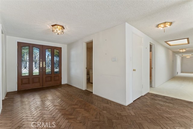 Wood chevron patterned floors in the welcoming foyer.