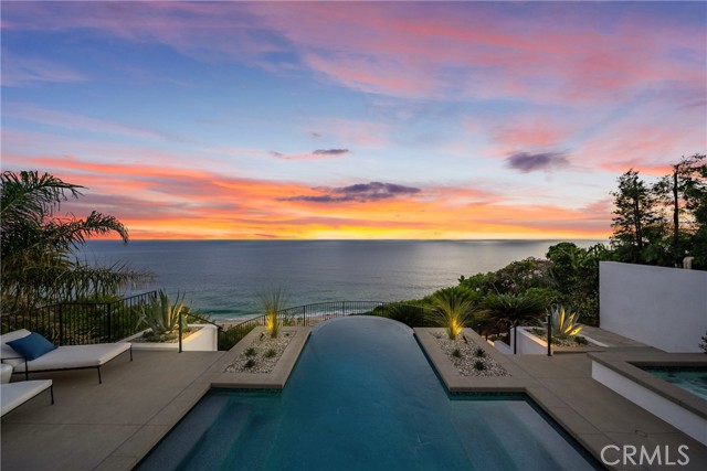 Perched majestically on a half-acre oceanfront bluff overlooking the beautiful Southern California coastline, 32101 Coast Hwy embodies the epitome of luxury Laguna Beach living. This stunning estate features panoramic white water, ocean, Catalina Island, sand, and coastline views. A one-of-a-kind home, it has been completely remodeled to the highest quality. A large bluff-top infinity pool with spa and pool house boast panoramic vistas: an architectural rarity that would never be approved if submitted today. This home was transformed into a contemporary Santa Barbara-style masterpiece by renowned architect James Conrad. Upon entry, the sprawling main level open floor plan immediately captivates with stunning panoramic ocean views. The main level features a spacious living room, dining room, gourmet chef's kitchen, powder room, luxurious primary suite, and magnificent outdoor decks all designed to maximize natural light and ocean vistas. The seamless flow extends to the lower level, where a large family room opens onto the expansive deck overlooking the pool, spa, and ocean. The lower level features three bedrooms, three bathrooms with immaculate tile work, spacious laundry room, and direct access to the pool deck, seamlessly blending indoor and outdoor living. Additional interior touches include incredible custom tile flooring, with ceilings featuring white oak beams and tongue & groove design. Moving outside, lush landscaping and a fully remodeled pool, spa, and waterfall delight the senses. Additionally, the pool house features a beautiful bathroom and bar. New roofing strategically integrates solar panels into the shingles. Three new sets of pocket doors and exterior steel doors with marine-grade finish, plus a brand-new Euroline steel front entry door complete the picturesque appearance. Every detail of this virtually brand-new home has been meticulously curated. The extensive three-year renovation included structural enhancements, updating the plumbing, electrical, & HVAC with state-of-the-art systems, and installation of top-quality windows. For a turnkey experience, the brand new elegant furnishings are available for purchase.
32101 Coast Hwy not only offers a luxurious residence, but a lifestyle characterized by coastal serenity and sophistication. Ideal for those seeking the ultimate in beachfront living, this property invites you to experience the pinnacle of Laguna Beach's coastal charm and beauty. Your one-of-a-kind coastal oasis awaits!