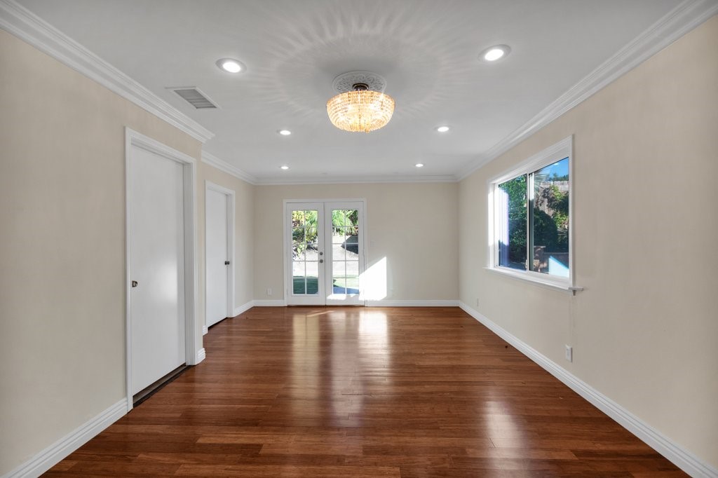 One of the bedrooms - gleaming hardwood floors - french door leads to the backyard