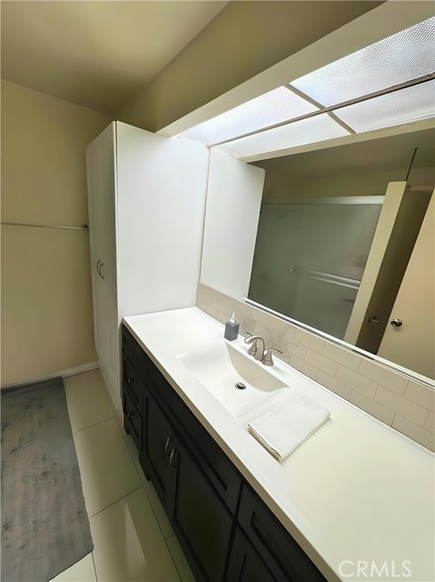 Modern en-suite with shower/tub combo. Linen cabinet installed  for functionality & convenience.