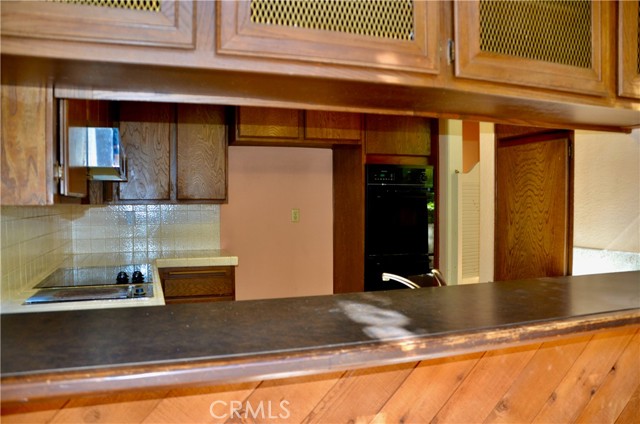 Basic Layout of the Kitchen with Electric Stove top with grill, double ovens and dishwasher under main counter near sinks.