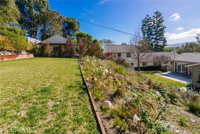 The upper level yard is an expansive lawn perfect for play, relaxation and other outdoor activities.