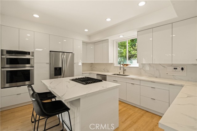 modern kitchen with clean lines, quartz counters, stainless steel appliances