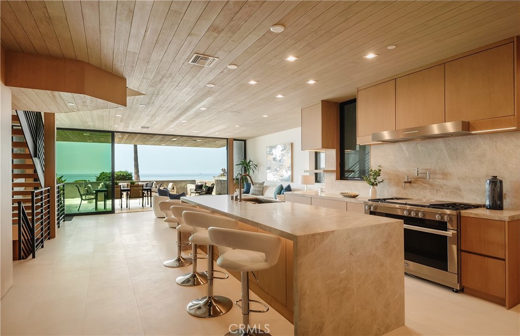 Welcome to one of the most unique, quality designed and built Strand homes in Manhattan Beach. This Mid-Century beach modern home is perfect for family fun with 180 degree ocean views from Palos Verdes to Malibu. Let's start with the largest outdoor patio on the entire Strand boardwalk... at 714 square feet (300 square feet is covered) you'll be entertaining family and friends. 1st floor living has an open floor plan featuring floor to ceiling sliding Fleetwood glass doors the width of the property. The kitchen is spacious with a large stone waterfall island ideal for food prep and dining. Amenities include a large walk-in pantry, and top of the line Miele appliances featuring oven with warming drawers, microwave and extra large refrigerator. There's more fun waiting downstairs (use the three-story elevator for convenience). Basement features a theater room with built-in speakers and carpet flooring providing ideal acoustics for all your audio and video entertainment. Adjacent is a flex room which can be a playroom for kids or an area to set up the gym equipment. The entire recreation area is attractively paneled with floor to ceiling Oak Wood Veneer to keep noise to a minimum. The large laundry room with built-in upper and lower cabinets and sink is located conveniently near the elevator. Now it is time to luxuriate in your Master Bedroom on the second floor. Again, the stunning, unobstructed ocean views are yours to enjoy from the moment you wake up thanks to floor to ceiling sliding Fleetwood doors. A beautiful, fully appointed bathroom has a bathtub overlooking the ocean, a large glass shower, wall mounted toilet and a wide double sink counter. Other amenities include: Oak wood veneer floor to ceiling paneling, white oak flooring, recessed lighting in all rooms, multi-zoned A/C, tankless water heaters and 2 car garage parking with one additional spot for guests.