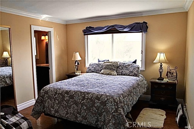Sunlit bedroom with a full bath and mirrored closet sliding doors.