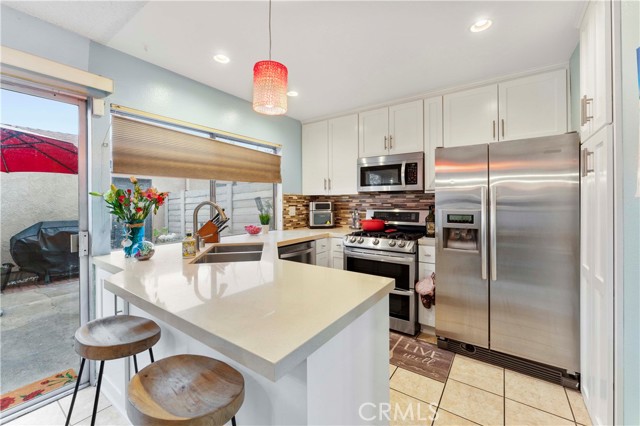 Blinds at window open from top or bottom. Kitchen was newly updated in the last three years with shaker cabinets and quartz counters, pendant lighting, recessed lighting, and backsplash. Appliances to remain. Just enough space to casually sit at the counter.