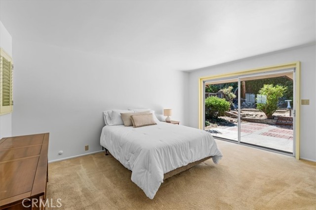 Primary Bedroom with sliding glass door to backyard.