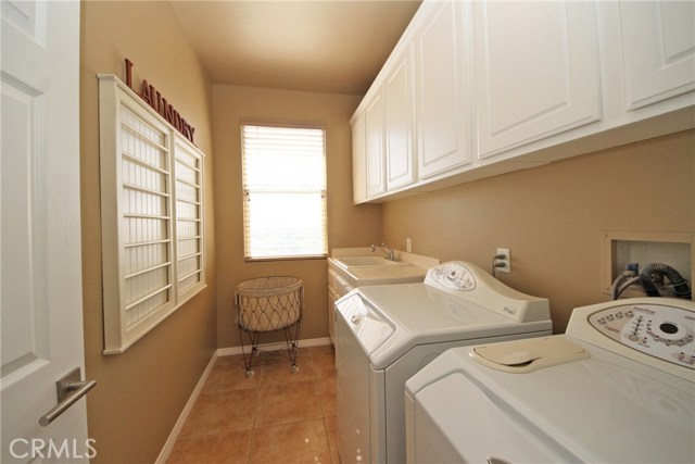 2nd level laundry room with sink and storage