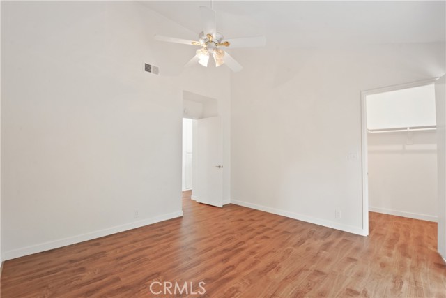 Another view of the back bedroom, with decorative ceiling fan, newly installed laminate flooring and walk-in closet