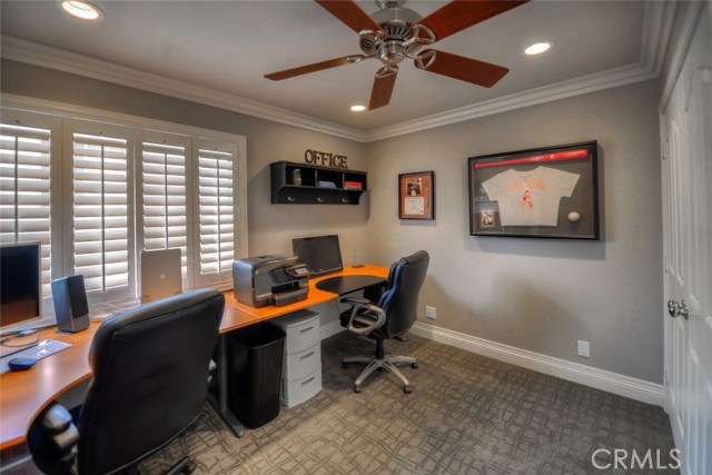 Fourth upstairs bedroom with plantation shutters, ceiling fan, room closet, crown molding, recessed lighting, currently being used as an office.