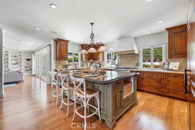 Gourmet Kitchen With different wood stain cabinets and darker stone countertops that complements the darker stained perimeter cabinets and lighter stone countertops.